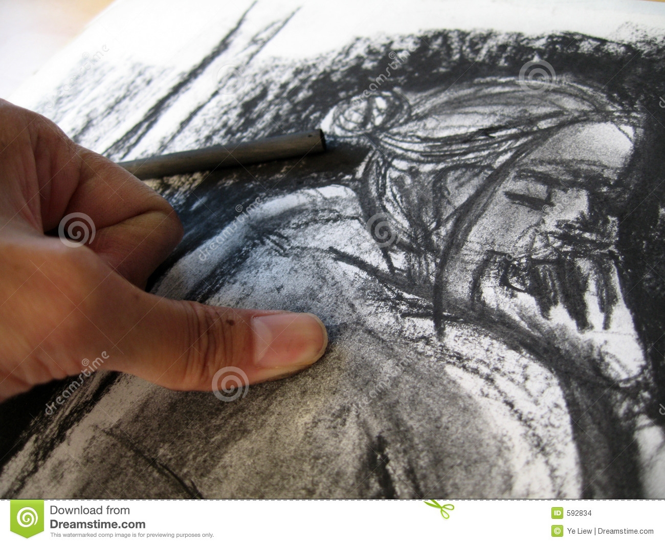 Рука рисует углем