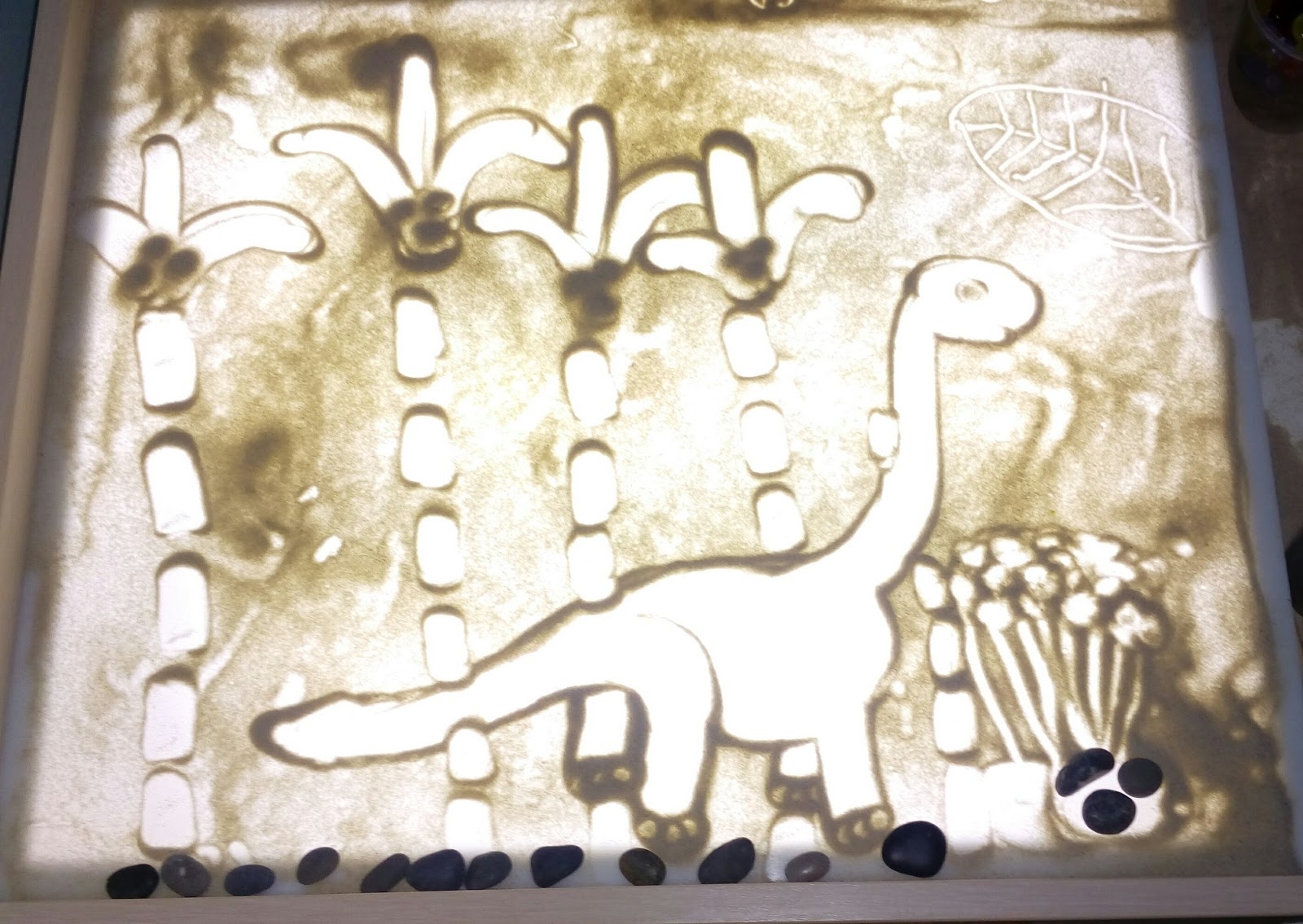 Рисование песком динозавров